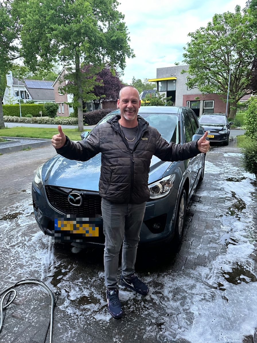 Tevreden klant voor een schone Mazda na een wasbeurt